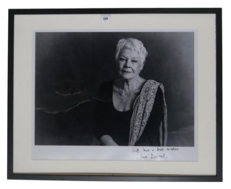 A large portrait photograph of Dame Judy Dench, signed "with love &amp; best wishes" to lower border, framed under Perspex, m