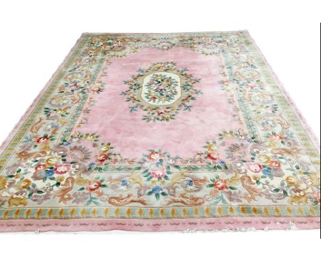 CHINESE CARPET, 375cm x 275cm, floral medallion on a rose pink field within an oversized corresponding border.