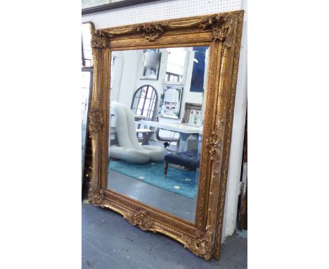 MIRROR, Louis XV style, having an ornate gilt swept frame with bevelled edge plate, 130cm W x 160cm H.