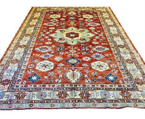 FINE KAZAK CARPET, 350cm x 261cm, central medallion on a ruby field of scattered geometric amulets within complimentary bands