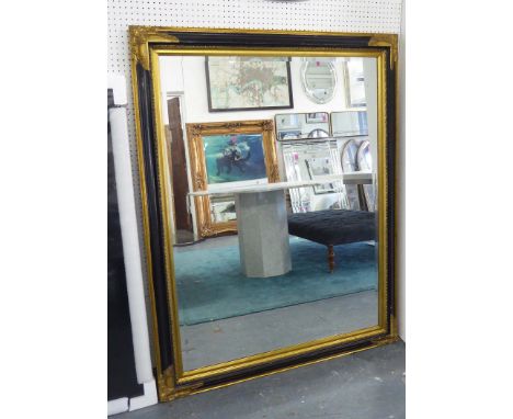 MIRROR, bevelled in a gilded and ebonised frame, 141cm x 110cm.