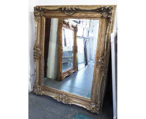 MIRROR, Louis XV style, having an ornate silver gilt swept frame with bevelled plate, 130cm W x 160cm H.