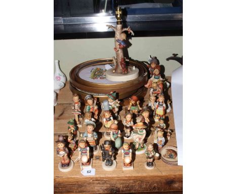 Collection of twenty five Hummel figures and a Hummel lamp, three small dishes and six Hummel design needleworks.
