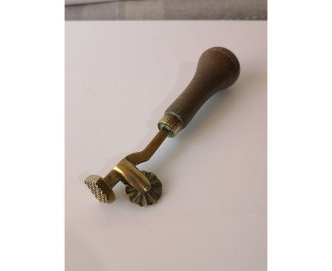 A VINTAGE BRASS &amp; WOOD LEATHER WORKING TOOL. 