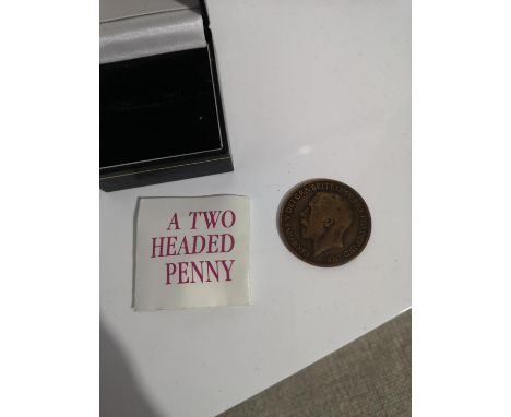 A TWO HEADED PENNY GEORGE V COIN WITH SMALL LEAFLET. 