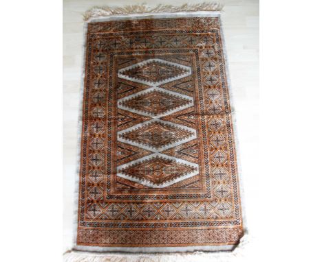 An Oriental silk hand-knotted ivory -ground prayer rug with blonde lozenge-shaped designs to centre, double border and long f