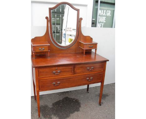 An Edwardian mahogany and cross banded dressing chest with shield-shaped mirror, two small and one long drawer under on squar