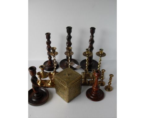 An assorted lot of brass and wooden candlesticks, vases to include six pairs and a brass tea caddy with lined interior 