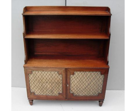 A pair of Regency mahogany waterfall cabinets with three-quarter gallery surround to top, two cupboards under with fabric-lin