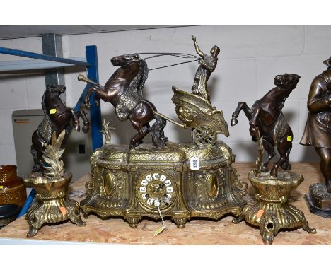 A VICTORIAN STYLE BRASS AND BRONZED CLOCK GARNITURE, the clock with female figure in a chariot, enamel dial with Roman numera