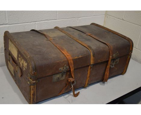 A DISTRESSED VINTAGE TRAVELLING TRUNK, with travel labels, width 84cm x depth 54cm x height 36cm