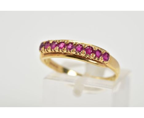 AN 18CT GOLD RUBY RING, of half hoop design set with nine circular cut claw set rubies, to a plain band, with an 18ct hallmar