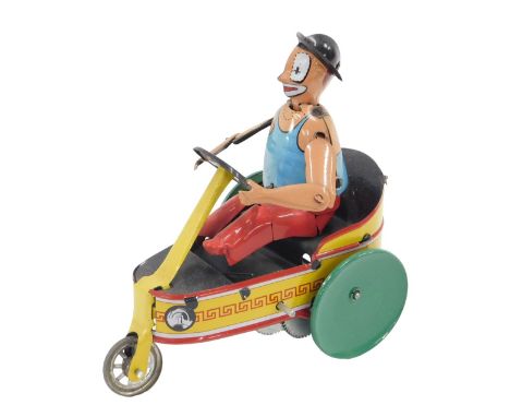 A modern tin plate toy clown, riding a three wheeled car, stamp to reverse PH. 