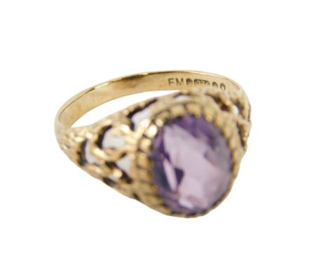 A 9ct gold amethyst dress ring, the oval cut amethyst in claw setting, with pierced design bark effect shoulders, ring size K
