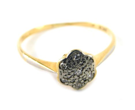 A floral diamond cluster ring, the platinum ring head set with seven tiny diamonds, on a yellow metal band, marked 18ct, ring