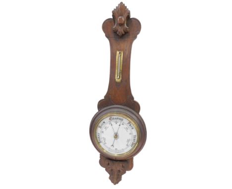 An early 20thC aneroid wheel barometer, with porcelain dial, in a carved oak case, 87cm high.