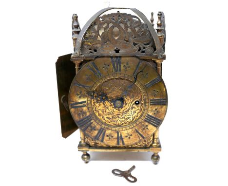 A brass lantern clock, the brass dial with Roman numerals, with pierced fish and flower decoration, the bell top needs repair