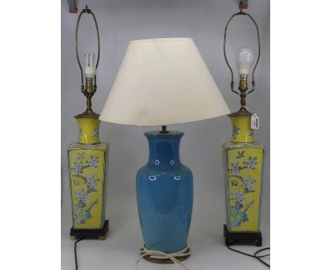 A pair of ceramic table lamps, each of square tapering form, decorated with birds and flowers on a yellow ground, height 78cm