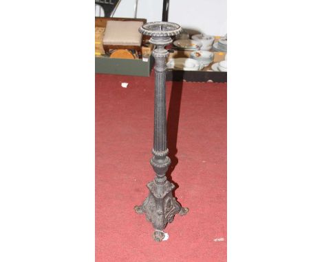 A cast iron ecclesiastical style pricket candlestick, having a single sconce on a fluted column and triform base, h.69cm 