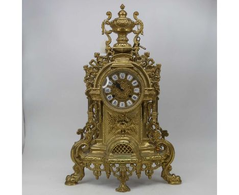 A large 18th century style brass cased mantel clock, the circular dial with raised enamelled plaques and Roman numerals with 