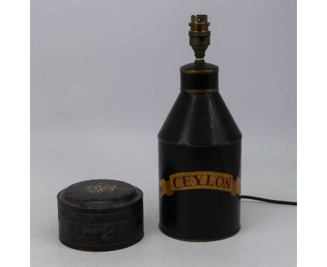 A toleware tin converted to a table lamp, black painted with Ceylon within scroll, height 32cm (including fittings), together