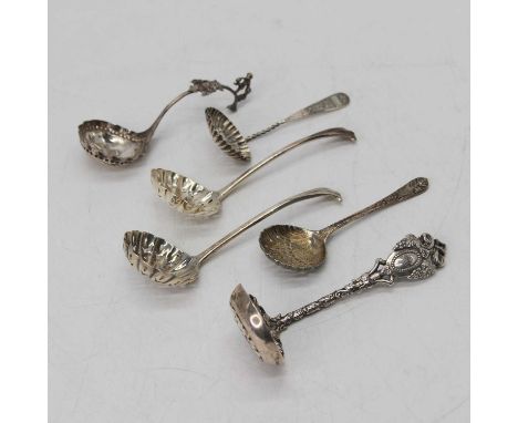 A Victorian ornate silver sifting spoon, having vine decoration, London 1873; together with four further silver sifting spoon