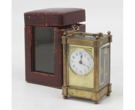 An early 20th century lacquered brass carriage clock, the circular enamelled dial showing Arabic numerals, having visible pla