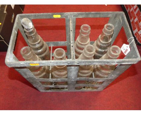 A collection of seven moulded glass motor oil bottles, to include ESSO Lube in galvanised crate