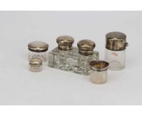 A George V silver mounted cut glass desk stand, containing two inkwells and a pen tray, w.11cm; together with four silver mou