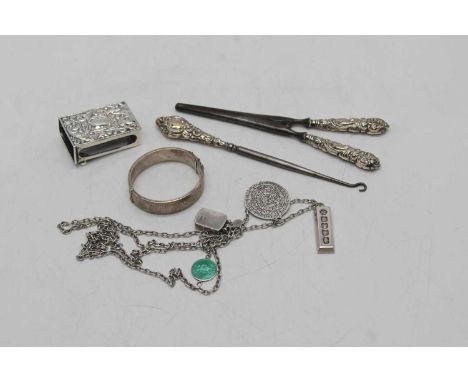 A Victorian silver matchbox holder, having repousse decoration (a/f), Chester 1886; together with a hinged silver bangle; and