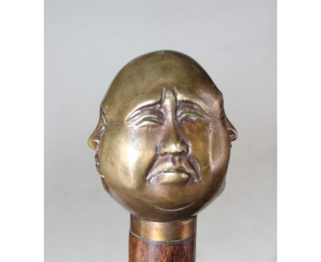 A reproduction hardwood walking stick, the handle in the form of a four-faced Buddha, length 92cm
