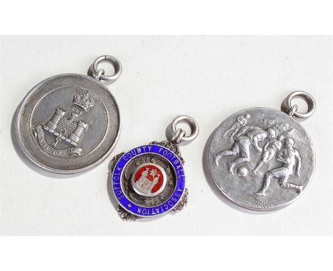 Three silver football medals, two depicting figures playing football, the third for the Suffolk County football, (3)