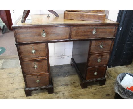 An early 19th Century mahogany leather topped eight drawer desk on shaped bracket feet
