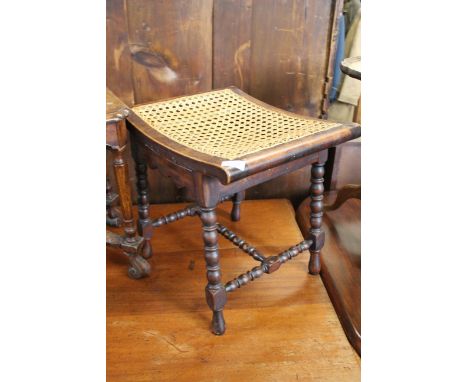 A late 19th Century mahogany bobbin turned stool with bergere seat