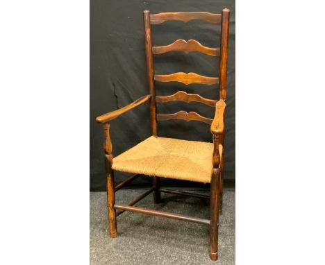 A 19th century elm ladder back armchair, shaped cresting rail, rush seat, 108cm high. c1860. 