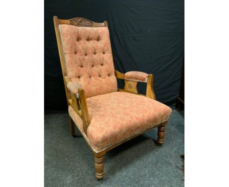 A Victorian mahogany fireside low armchair, carved top rail, button back, turned legs, ceramic casters, c.1890 