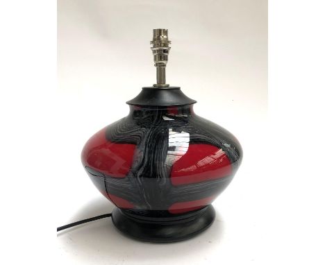 A glass table lamp of compressed form, red and black, 33cmH to top of fitting 