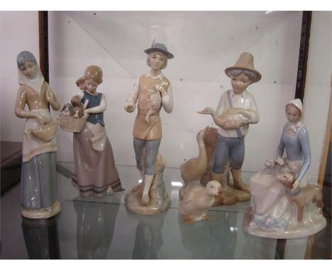Lladro style porcelain figures.  A girl with dogs, a girl carrying a duck, a boy carrying a duck, a girl with puppies (a/f), 