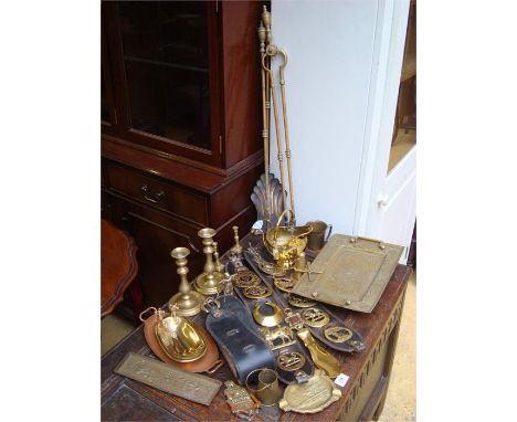 A box of mixed brass to include horse brasses, fire tools, candlesticks etc. 