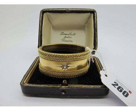 A Victorian Diamond Set Wide Hinged Bangle, star set to the centre with an old cut stone, within textured border, hinged to s