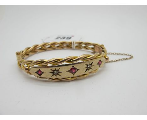 A Victorian Hinged Bangle, of twisted design, star set to the front, hinged to snap clasp (indistinctly stamped ) (internal d