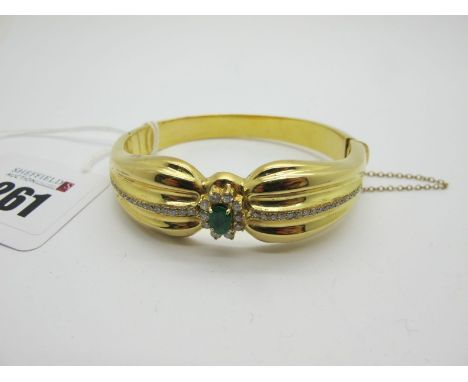 A Modern Emerald and Diamond Set Hinged Bangle, oval claw set to the centre, of shaped design with line highlights, hinged t 