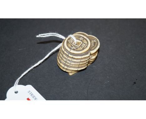 A Japanese carved ivory netsuke, Meiji period, of a pile of coins, 4cm wide.
