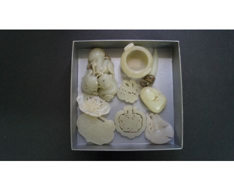 A collection of nine Chinese carved pale celadon jade carvings, to include: a pendant, 7.1cm wide; a twin handled tripod cens