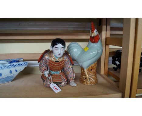 A Japanese Satsuma porcelain Samurai, kneeling with a scroll in his right hand, 19cm high; together with a Chinese celadon co