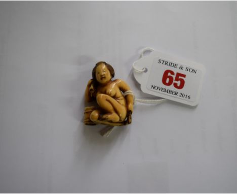 A Japanese carved ivory netsuke, Meiji period, of a crouching naked young woman with a towel, signed, 3.8cm high. Condition R