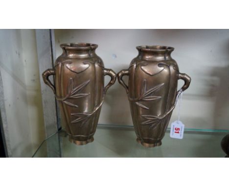 A pair of Chinese brass twin handled vases, seal marks to bases, each moulded in relief with bamboo, 22cm high. (2)