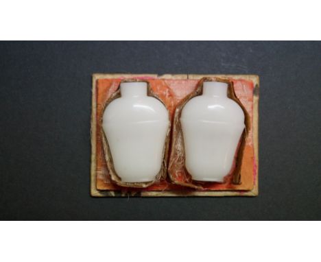 A pair of Chinese 'mutton-fat' white jade snuff bottles, 5.1cm high, in fitted box. (2)