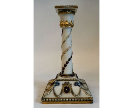 A Royal Worcester biscuit glazed china candlestick, decorated in neo-classical taste with silvered rams' heads, rosettes and 