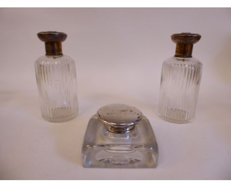 A pair of cut glass cologne jars with applied silver collars and engraved silver gilt, mushroom shaped caps; and a cast glass
